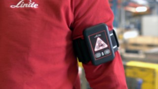 Der Distance Beeper von Linde hilft, den gesunden SIcherheitsabstand einzuhalten Der Distance Beeper von Linde am Arm eines Beschäftigten