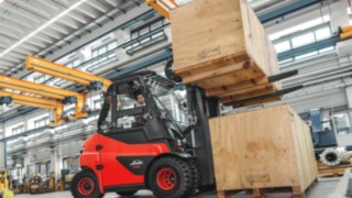 E-Stapler beim Transportieren von schweren Kisten E-Stapler beim Transportieren von schweren Kisten