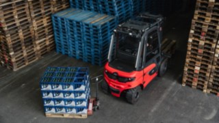 Die leistungsstarken Sensoren des Linde Reverse Assist Radar erkennen zuverlässig stationäre und bewegliche Objekte. Der Linde E-Stapler X30 fährt rückwärts aus einem Gang heraus geradewegs auf ein Hindernis aus Getränkekisten zu.