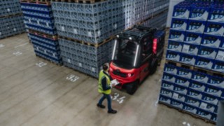 Das Assistenzsystem Linde Reverse Assist Radar erkennt Objekte und Personen im Rückwärtsfahren und warnt vor Zusammenstößen. Der Linde E-Stapler X30 fährt rückwärts aus einem Gang heraus, im Rückräum steht ein Fußgänger.