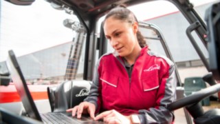 Durch die drahtlose Übertragung der Fahrzeugdaten lassen sich die Serviceprozesse optimieren. Servicetechnikerin bei der Fehlerdiagnose am Laptop.