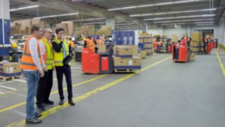 Linde Safety Scan wird vor Ort eingesetzt. Drei Personen analysieren die Begebenheiten in einer Fabrikhalle.