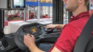Die Steuerung des Multifunktionshebels trägt zu präzisen, sicheren Manövern bei und hilft, Unfälle zu vermeiden. Mitarbeiter bedient den Multifunktionshebel in einem Fahrzeug von Linde Material Handling