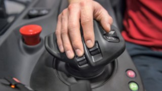 Die Form des Linde Multifunktionshebels ist exakt auf die menschliche Anatomie angepasst. Hand des Staplerfahrers liegt auf dem Multifunktionshebel von Linde Material Handling