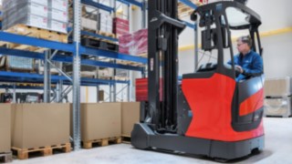 Der Linde Multifunktionshebel ermöglicht alle zentralen Steuerfunktionen der Schubmaststapler der Baureihe 1120 mit einer Hand. Mitarbeiter verräumt Waren in einem Fahrzeug von Linde Material Handling