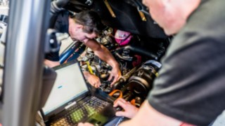 Techniker führt Inspektion eines Gebrauchtstaplers durch Techniker mit Laotop beim der Inspektion eines Staplers zur Aufbereitung